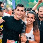 Group of runners smiling in the rain during a marathon race event.